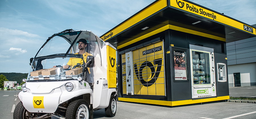Pošta Slovenije branded parcel locker with a delivery vehicle parked outside
